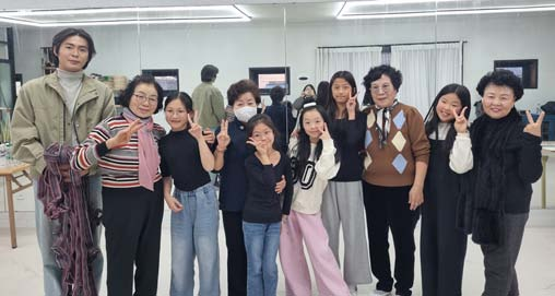 전시장에서 어르신과 청년예술가가 완성한 작품 앞에 함께 서 있는 모습
